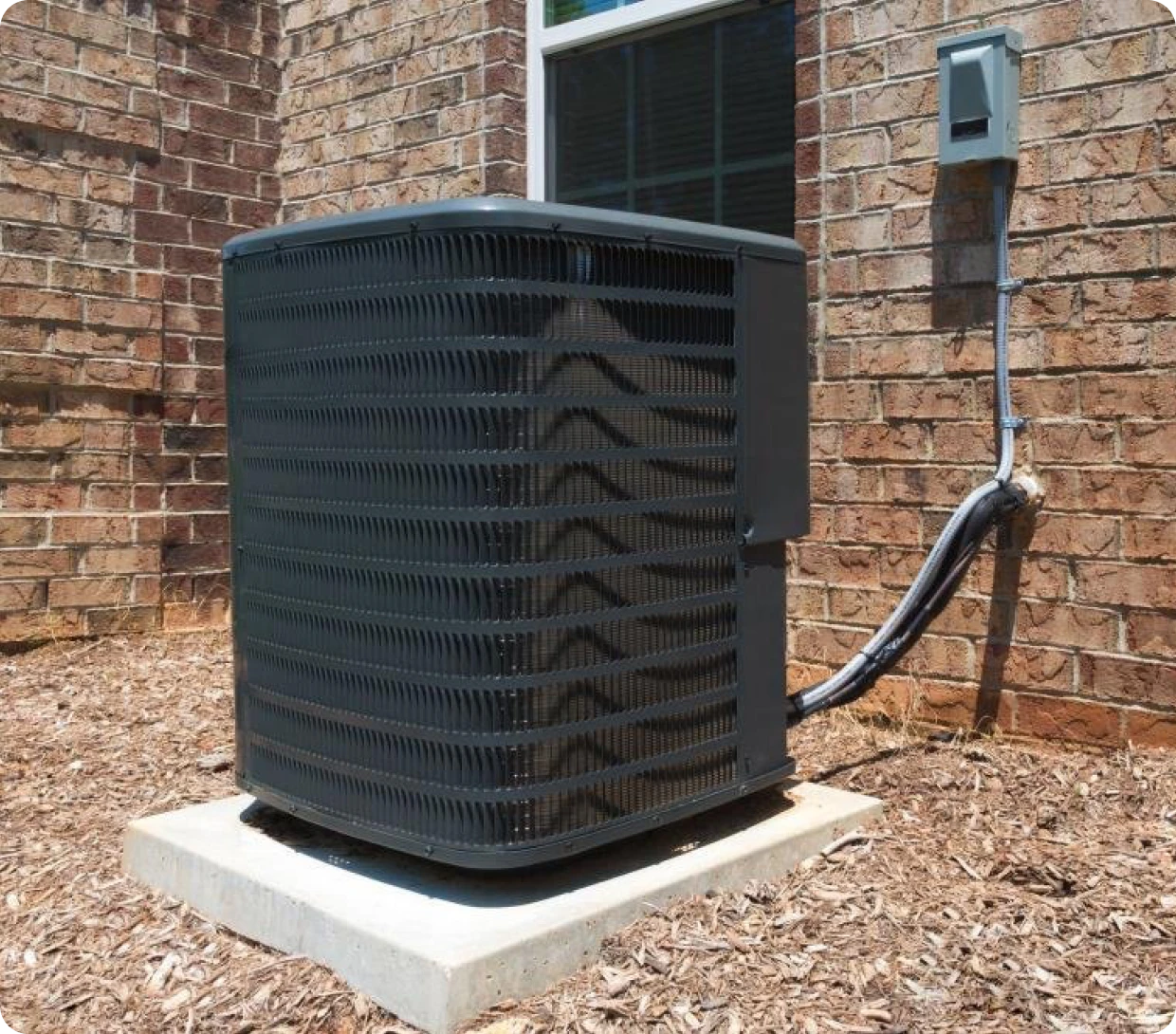 Outdoor air conditioning unit beside brick wall.