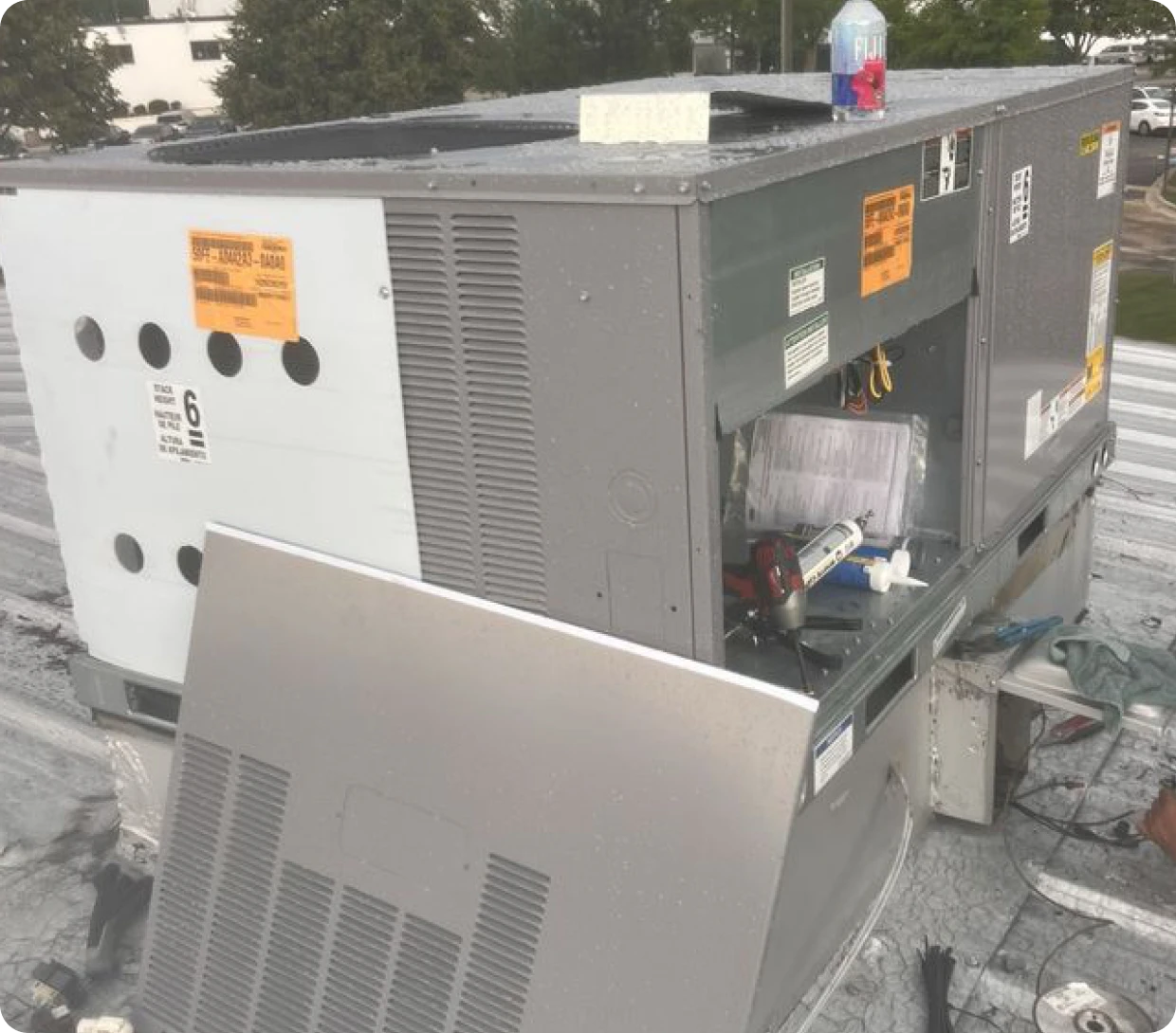 Rooftop HVAC unit under maintenance with tools.