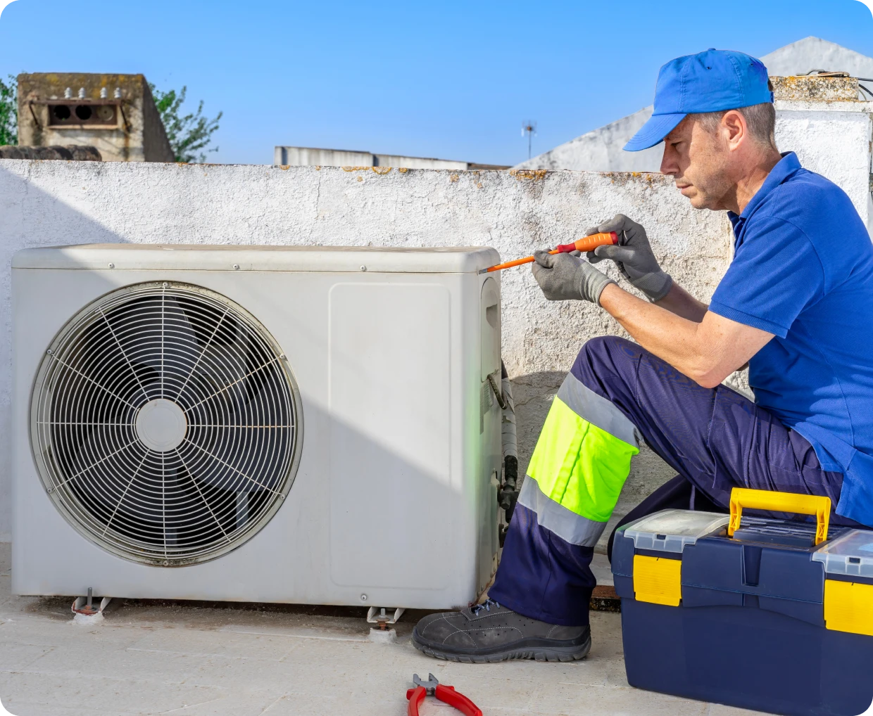 Technician repairing an outdoor air conditioning unit.