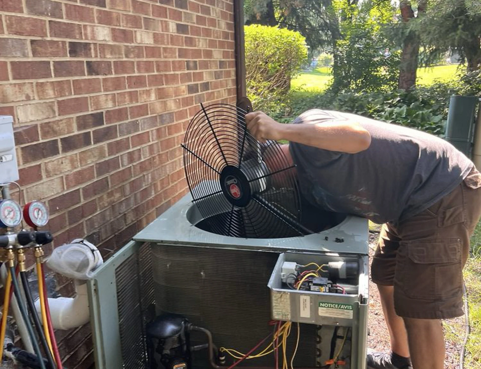 Technician examining outdoor air conditioning unit.